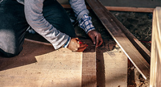 Image of Man measuring boards of wood